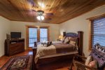 Queen bedroom with TV and private deck with mountain views